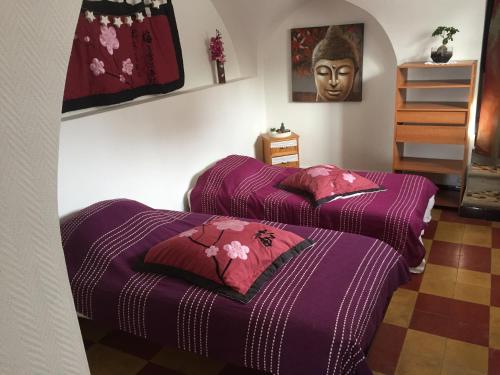 2 Betten in einem Zimmer mit einem Kopf an der Wand in der Unterkunft Le gite du moulin in Lablachère