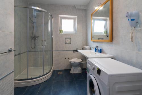 a bathroom with a shower and a toilet and a sink at Apartments Karabaić Krk in Krk