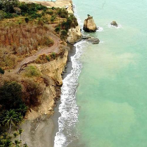an aerial view of the ocean and a rocky shore at Hosteria Cumilinche in Same