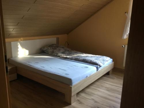 Bett in einem Zimmer mit Holzboden in der Unterkunft Alte Salzstraße 43 Ferienwohnung in Brietlingen