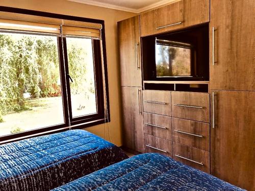 um quarto com uma cama e uma grande janela em Mirabosque New Apartments 3 em Osorno