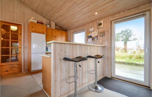 a kitchen with a counter and a stools in a room at Holiday Home Kap Farvel Rømø Ii in Bolilmark