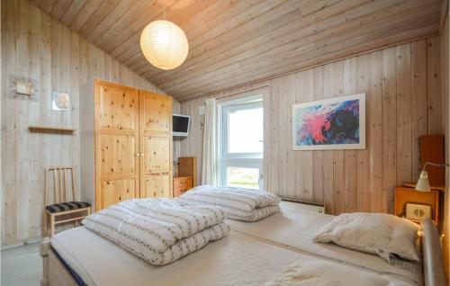 two beds in a room with wooden walls at Awesome Home In Rm With 3 Bedrooms, Sauna And Wifi in Bolilmark