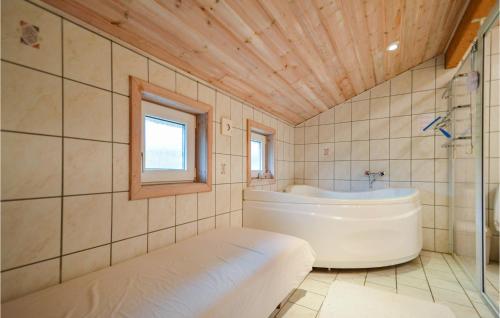 a bathroom with a white tub and a window at Holiday Home Kap Farvel Rømø Ii in Bolilmark