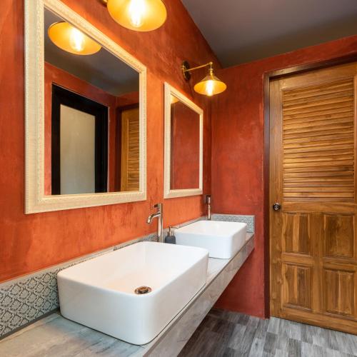 a bathroom with two sinks and two mirrors at Tepbunthom Hostel in Bangkok