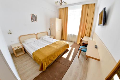 um quarto de hotel com uma cama e uma janela em Hotel Gallant em Sibiu