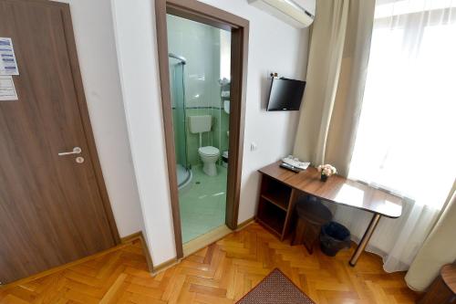 baño con aseo y puerta de cristal en Pension Alexia, en Sibiu