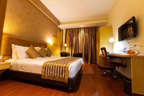 a hotel room with a bed and a desk at Ramada Neemrana in Neemrana