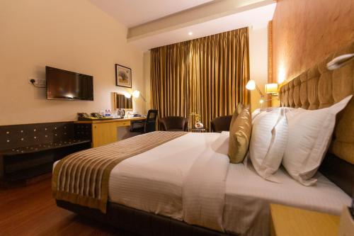 a hotel room with a bed and a desk at Ramada Neemrana in Neemrana