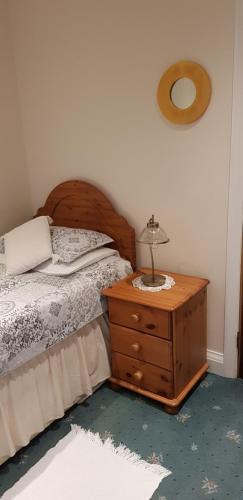 ein Schlafzimmer mit einem Bett und einem Nachttisch mit einer Lampe in der Unterkunft Milka's in Oxford