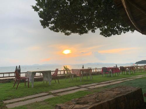 a row of tables and chairs on the beach at sunset at Anyavee Krabi Beach Resort in Klong Muang Beach