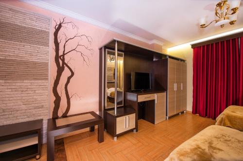 a room with a bedroom with a wall with a tree mural at Fieri International Hotel in Fier