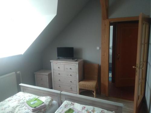 - une chambre avec un lit et une commode avec un miroir dans l'établissement Statek Olšany, à Olšany