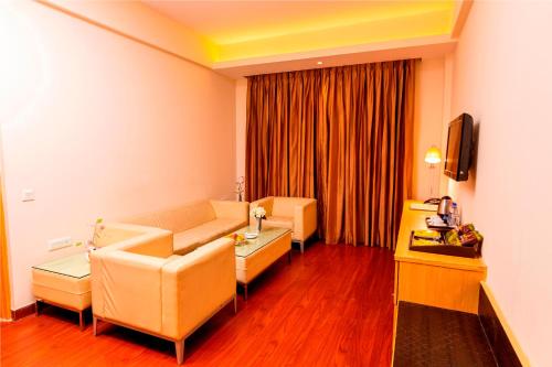 a living room with a couch and a tv at Ramada Neemrana in Neemrana