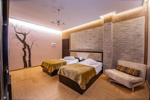 a hotel room with two beds and a chair at Fieri International Hotel in Fier
