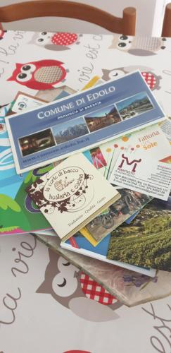 a table topped with lots of brochures and papers at Casa Ramus Valle Camonica a 30 km dal Passo Tonale in Edolo