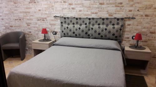 a bedroom with a bed and a brick wall at Lamarmora 58 in Sassari