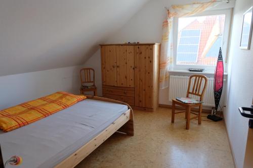 a bedroom with a bed and two chairs and a window at Afrikanisches Ambiente in Salzhemmendorf