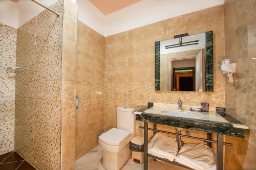 a bathroom with a toilet and a sink and a mirror at Fieri International Hotel in Fier