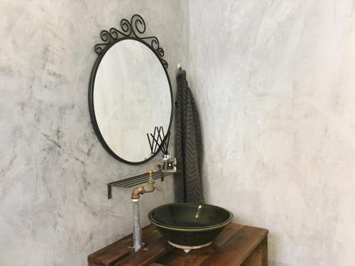 a bathroom with a green sink and a mirror at Wogoxette Upstairs, A Private Kampung Stay In Cameron Highlands in Cameron Highlands