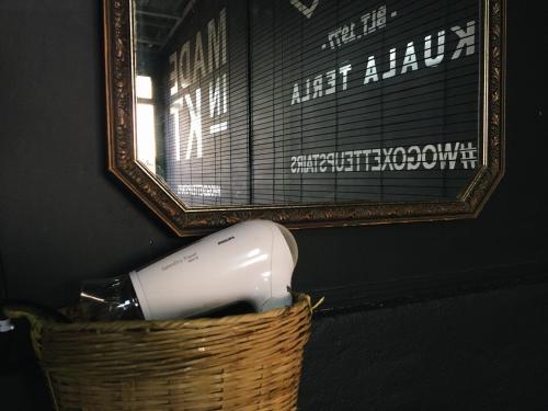 a hair dryer in a basket in front of a mirror at Wogoxette Upstairs, A Private Kampung Stay In Cameron Highlands in Cameron Highlands