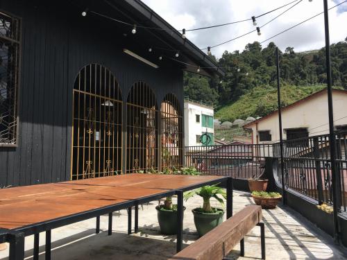 a wooden table and benches in front of a building at Wogoxette Upstairs, A Private Kampung Stay In Cameron Highlands in Cameron Highlands