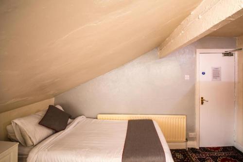 a bedroom with a bed in a attic at MyRoomz Hollingdales Hotel in Blackpool