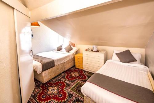 a small bedroom with two beds and a dresser at MyRoomz Hollingdales Hotel in Blackpool