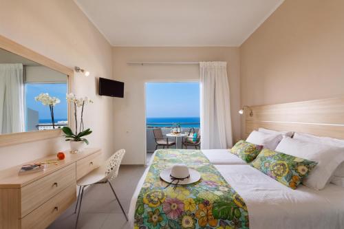 a bedroom with a bed with a view of the ocean at Oasis Scaleta Hotel in Skaleta