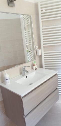 a white bathroom with a sink and a mirror at Casa Ramus Valle Camonica a 30 km dal Passo Tonale in Edolo