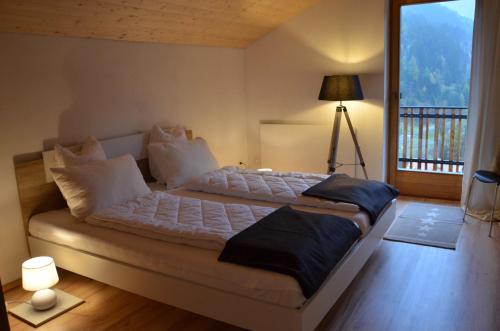 a bedroom with a large bed with a balcony at Stilfser Häuschen mit Blick auf König Ortler in Stelvio