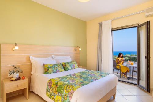 a hotel room with a bed and a view of the ocean at Oasis Scaleta Hotel in Skaleta