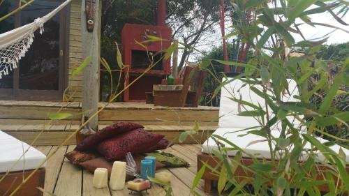 a pillow sitting on a wooden deck next to a plant at Las Casquivanas in Punta Del Diablo