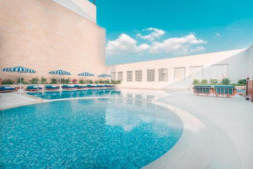 
a large swimming pool in a large building at Al Najada Doha Hotel by Tivoli in Doha
