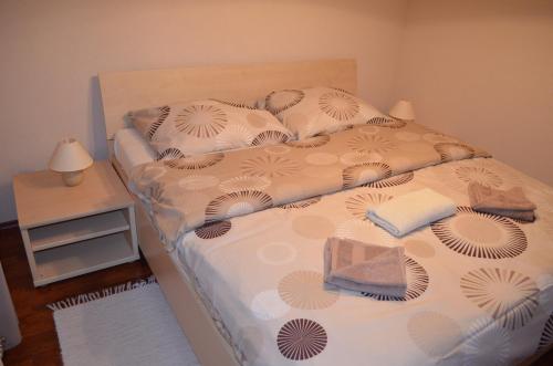 een slaapkamer met een bed en een nachtkastje met een lamp bij Apartmán Leny in Tatranská Lomnica