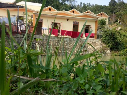 a house in the middle of a field of grass at Hoa Lan Hotel in Bak Kan