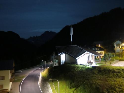 a house on the side of a road at night at Digonera Historic Hotel B&B in Rocca Pietore