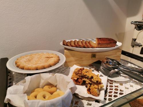 a table topped with plates of food and pies at A Casa di Tom in SantʼAmbrogio di Valpolicella