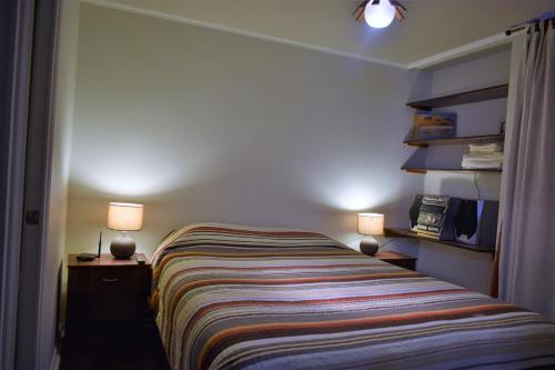 um quarto com uma cama com dois candeeiros em Dpto 1D 1B, Metro Bellas Artes, equipado full con WiFi em Santiago