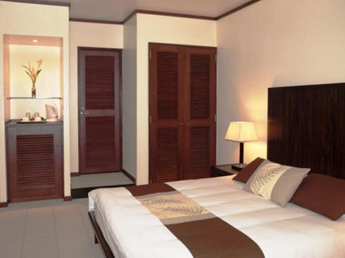 a bedroom with a large bed with wooden shutters at Solomon Kitano Mendana Hotel in Honiara