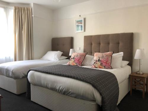 a hotel room with two beds and a window at Newton House Oxford in Oxford