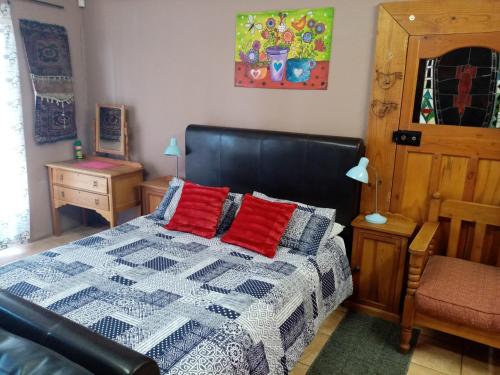 sypialnia z łóżkiem z czerwonymi poduszkami w obiekcie Oornagkamers@Hillstraat10 w mieście Douglas