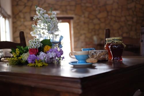 un tavolo in legno con fiori sopra di Agriturismo Podere Farnesiana a Tarquinia