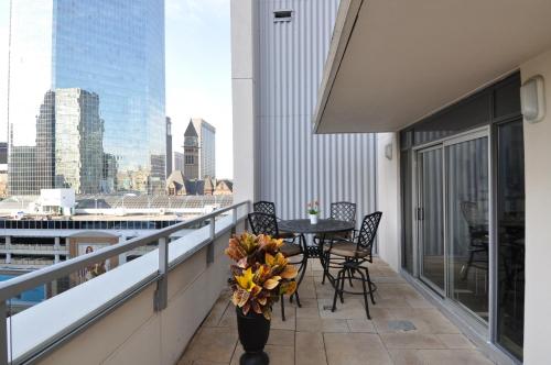 a balcony with a table and chairs and a view of a city at Yonge Suites Apart Hotel in Toronto