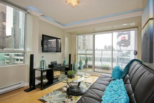 a living room with a couch and a large window at Yonge Suites Apart Hotel in Toronto