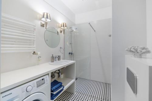 a white bathroom with a sink and a shower at Moon River Apartments Gdansk Old Town in Gdańsk
