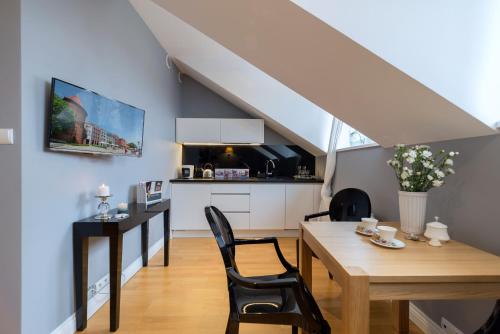 a kitchen and dining room with a table and chairs at Moon River Apartments Gdansk Old Town in Gdańsk