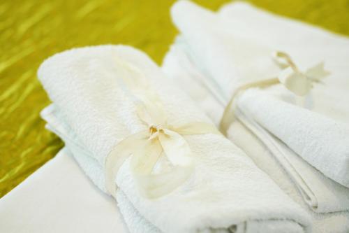 um grupo de toalhas brancas com um laço sobre elas em Firule Center Rooms em Split
