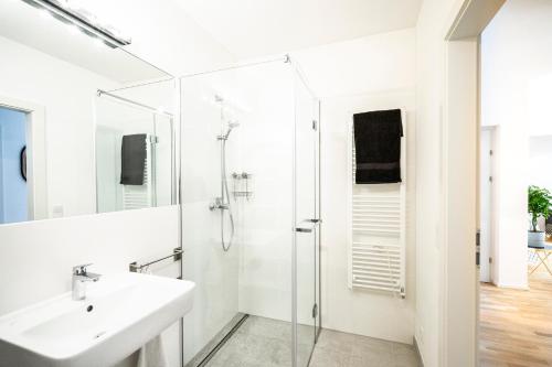 biała łazienka z prysznicem i umywalką w obiekcie Boutique Design-Apartments Vienna w Wiedniu