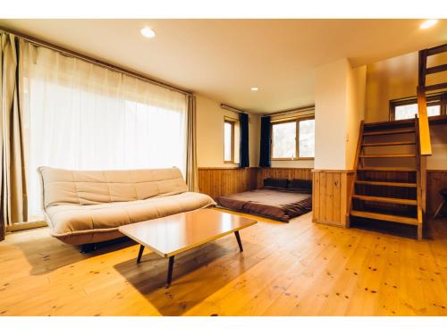 sala de estar con sofá y mesa de centro en LAKE view PRIVATE log house en Lake Toya